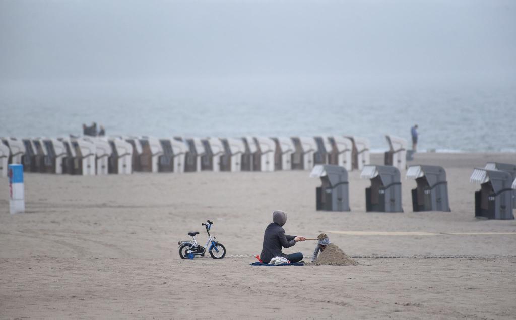 Das Sommerwetter macht eine Pause: Nur wenige Menschen sind am Warnemünder Strand. - Foto: Frank Hormann/dpa-Zentralbild/dpa