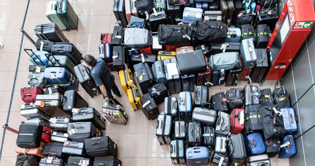 Stau bei der Gepäckabfertigung: Nach dem Ausfall einer Sortieranlage am Hamburger Flughafen, müssen die Koffer und Taschen von Hand zugeordnet und zu den Maschinen gebracht werden. - Foto: Markus Scholz/dpa