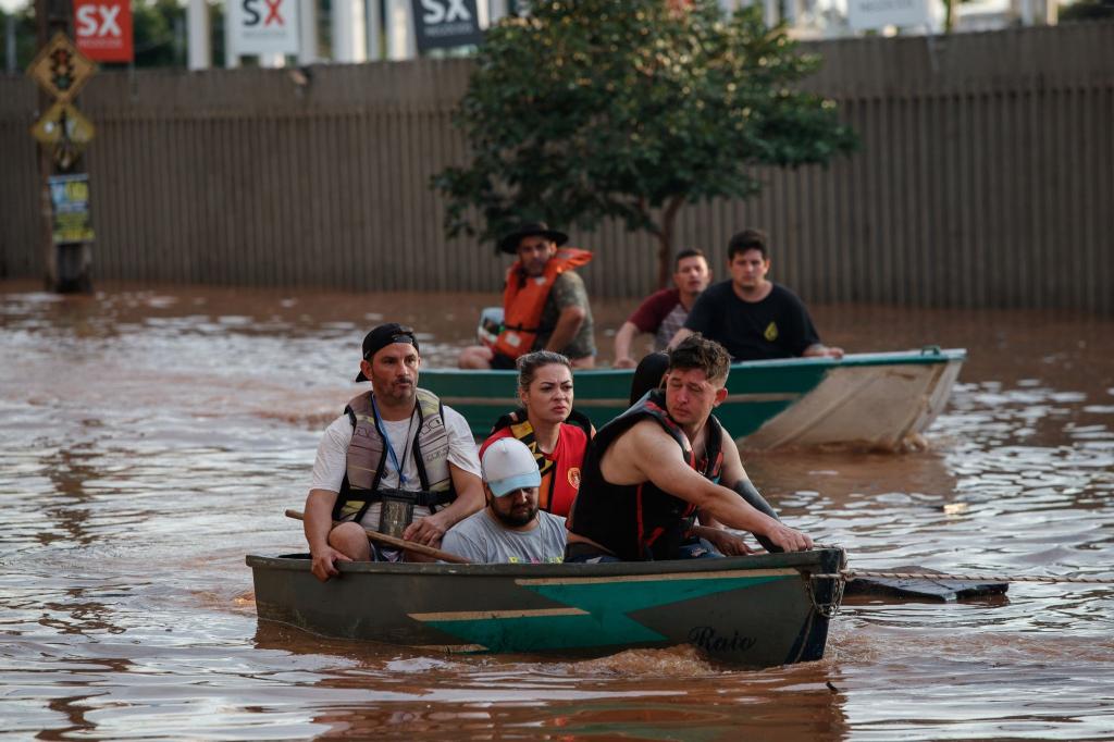 Mitglieder eines Rettungsteams bei der Evakuierung von Menschen, die von einer Überschwemmung betroffen sind. - Foto: Claudia Martini/XinHua/dpa