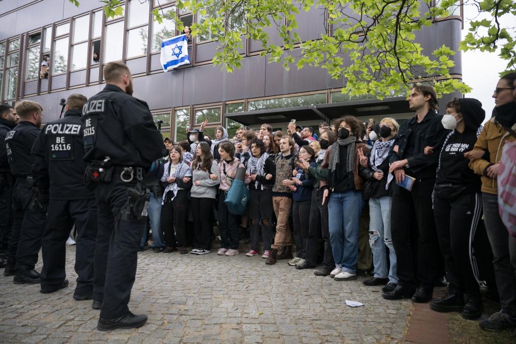 Polizei und Protestierende der propalästinensischen Gruppe «Student Coalition Berlin» stehen sich bei einer Demonstation auf dem Theaterhof der Freien Universität Berlin gegenüber. - Foto: Sebastian Christoph Gollnow/dpa