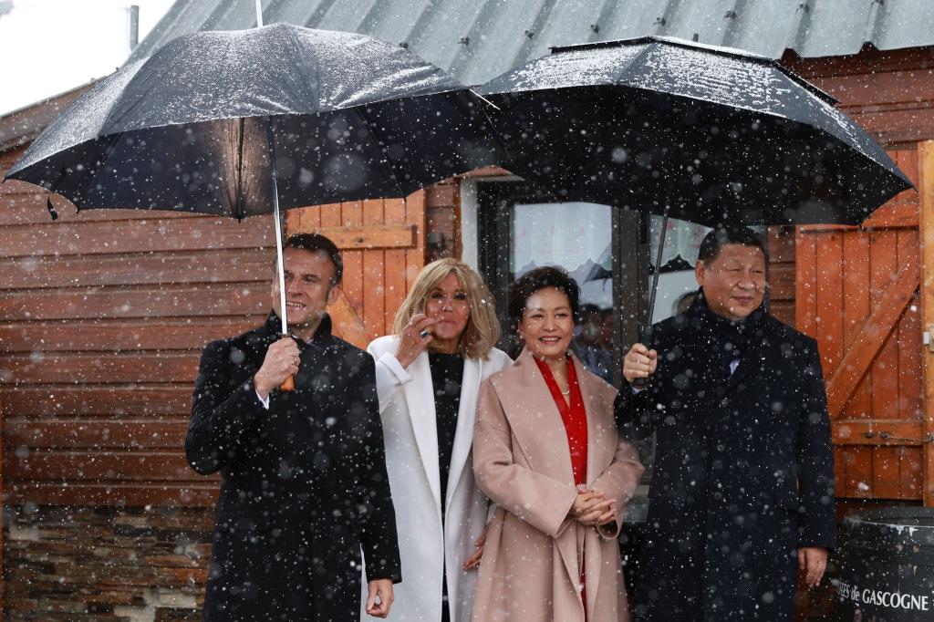 Ausflug bei Wind und Wetter: Der französische Präsident Emmanuel Macron und seine Frau Brigitte empfangen den chinesischen Präsident Xi Jinping sowie seine Frau Peng auf einem abgelegenen Bergpass in den Pyrenäen zu einem privaten Treffen. - Foto: Aurelien Morissard/AP Pool/AP/dpa