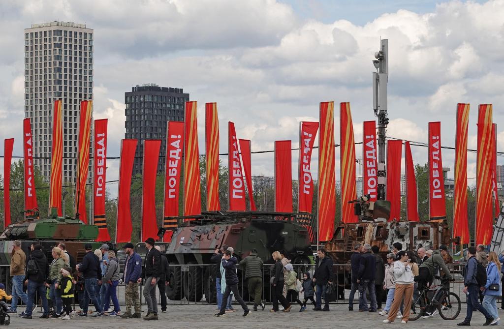 Menschen besichtigen eine Schau zu Kriegstrophäen im Park Pobedy (Park des Sieges) in Moskau. Gezeigt wird Militärtechnik aus verschiedenen westlichen Ländern und der Ukraine. Im Hintergrund zu sehen sind rote Fahnen mit der Aufschrift Pobeda! (auf Deutsch: Sieg). - Foto: Ulf Mauder/dpa
