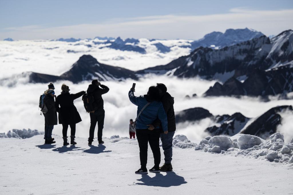 Über den Wolken.. Touristen genießen das Wetter auf dem Berg Chäserrugg in der Schweiz. Auf dem Gipfel kann wegen großer Schneemengen über das verlängerte Wochenende Wintersport betrieben werden. - Foto: Gian Ehrenzeller/KEYSTONE/dpa