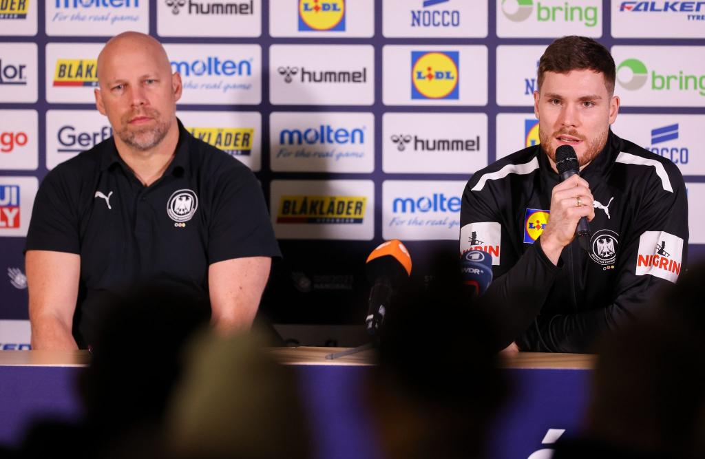 Axel Kromer (l) und Kapitän Johannes Golla sitzen während einer Pressekonferenz auf dem Podium. - Foto: Jan Woitas/dpa
