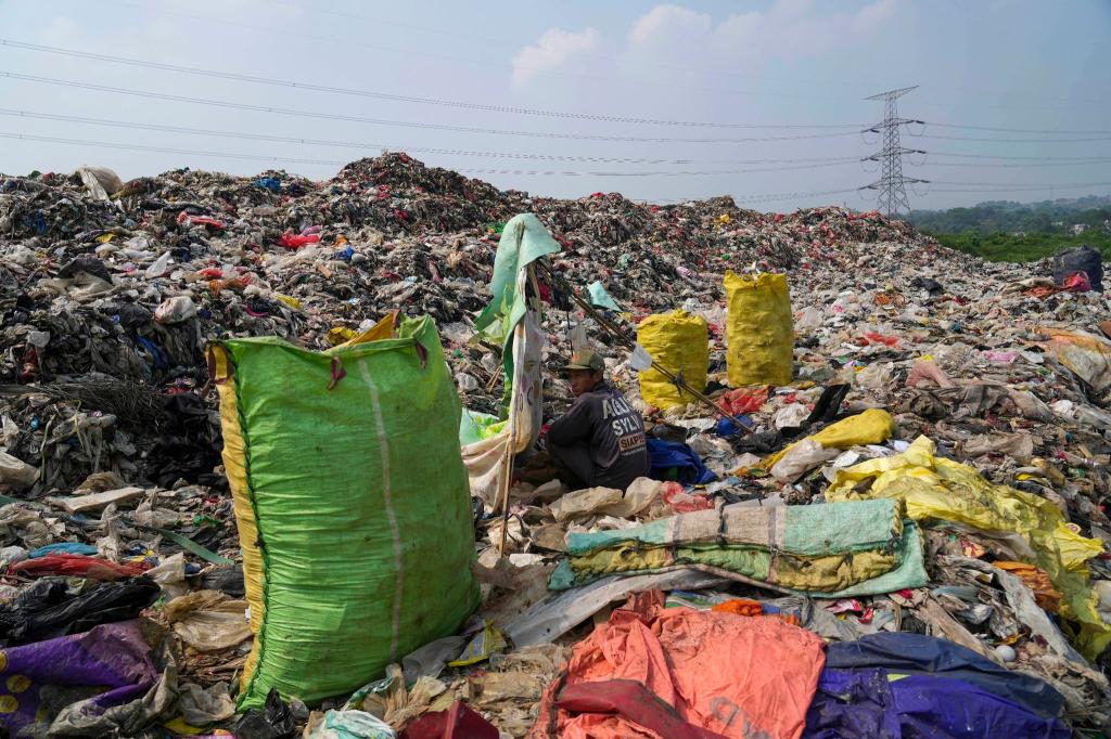 Einblick in die Umweltverschmutzung der Erde: In der Deponie in Depok am Rande von Jakarta türmt sich der Müll. Für diesen Lumpensammler, der sich ausruht, gehört der Anblick zum Alltag. - Foto: Tatan Syuflana/AP