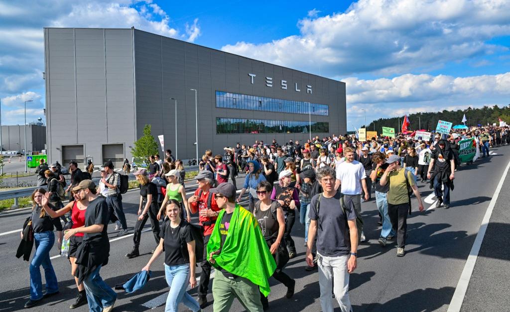 Teilnehmer einer Protestveranstaltung gehen zum Werk von Tesla. - Foto: Patrick Pleul/dpa