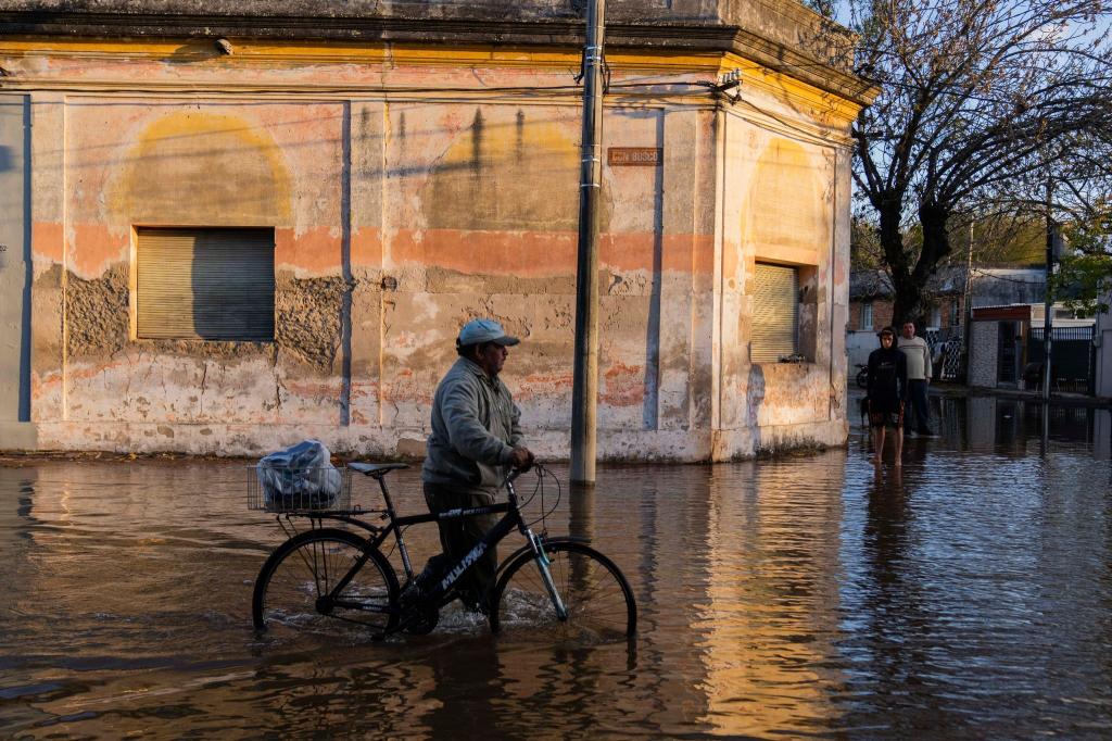 Nicht nur Brasilien hat mit heftigen Regenfällen und Hochwasser zu kämpfen - auch das Nachbarland Uruguay ist betroffen. Dieser Mann watet durch die überfluteten Straßen in Paysandú im Westen des Landes. - Foto: Matilde Campodonico/AP/dpa