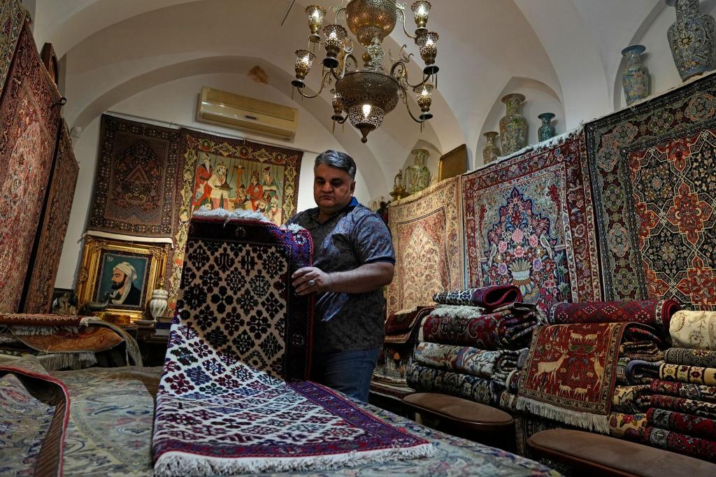 Ein iranischer Teppichhändler arbeitet in seinem Geschäft auf dem traditionellen Basar der Stadt Kashan. - Foto: Vahid Salemi/AP/dpa