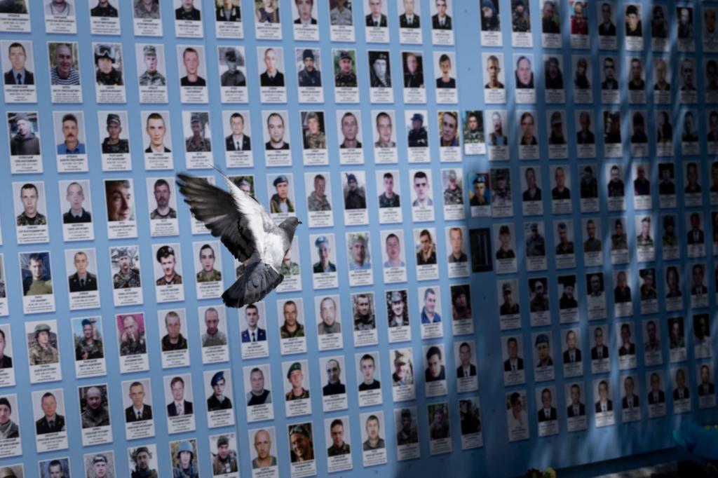 Zufall oder Botschaft? Während US-Außenminister Blinken die Gedenkmauer für gefallene ukrainische Soldaten in Kiew besucht, flattert eine Taube vorbei. - Foto: Brendan Smialowski/Pool AFP/AP/dpa