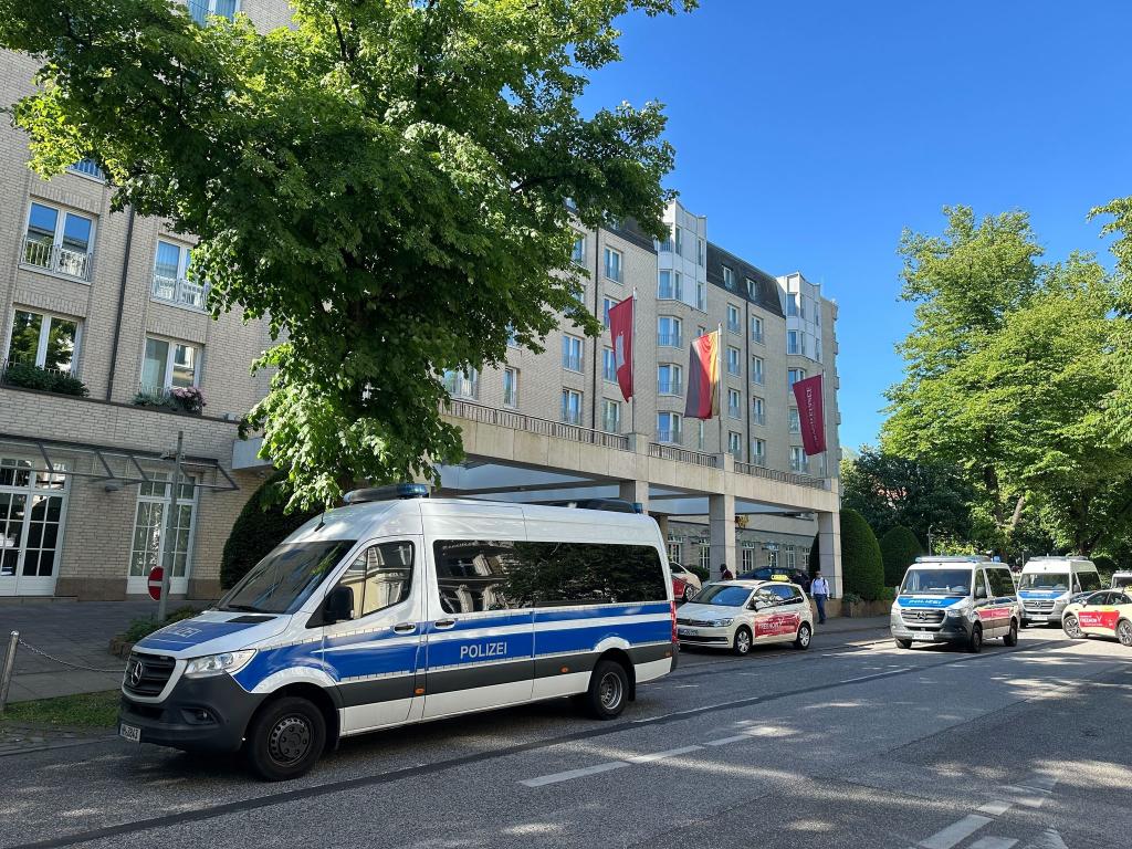 Polizeifahrzeuge vor dem Hamburger Élysée-Hotel. - Foto: Steven Hutchings/dpa