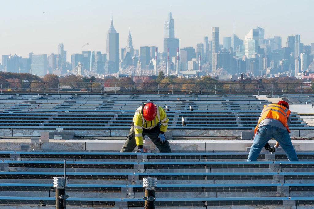 Elektriker installieren im New Yorker Stadtteil Queens Solarpaneele. Die US-Regierung hebt Zoll-Ausnahmen für bestimmte Solar-Importe auf. - Foto: Mary Altaffer/AP/dpa