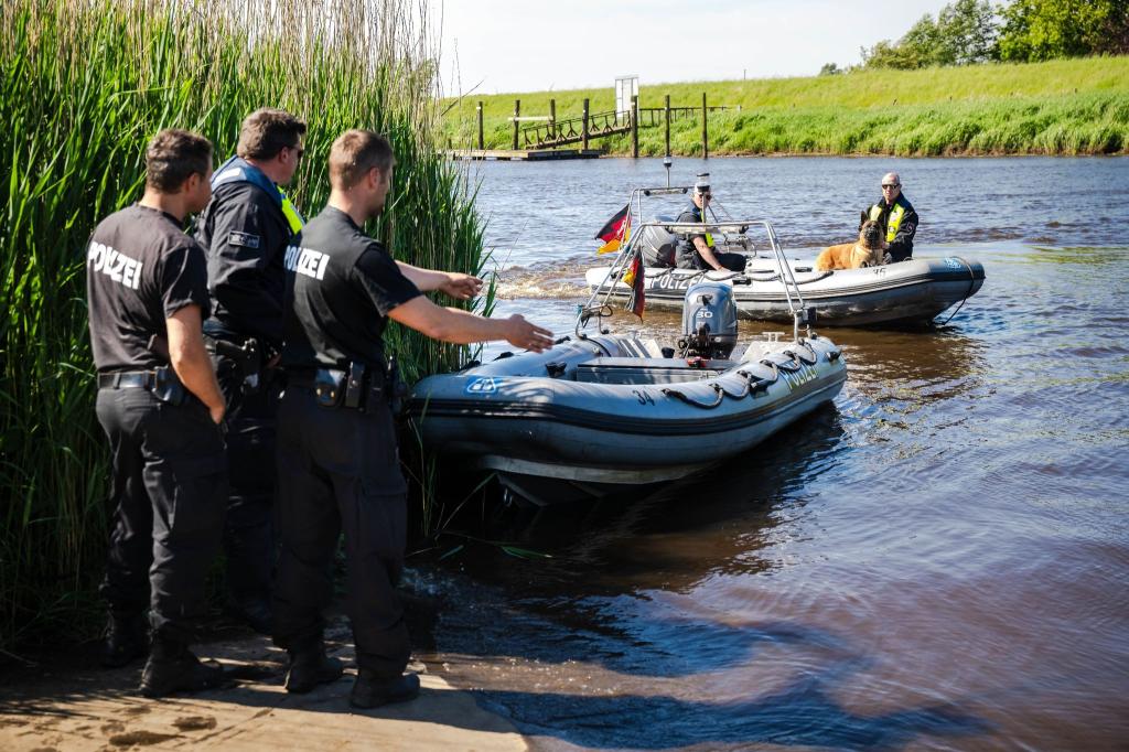 Einsatzkräfte der Polizei fahren bei der Suche nach dem vermissten Arian mit Spürhunden auf Schlauchbooten über die Oste. - Foto: Sina Schuldt/dpa