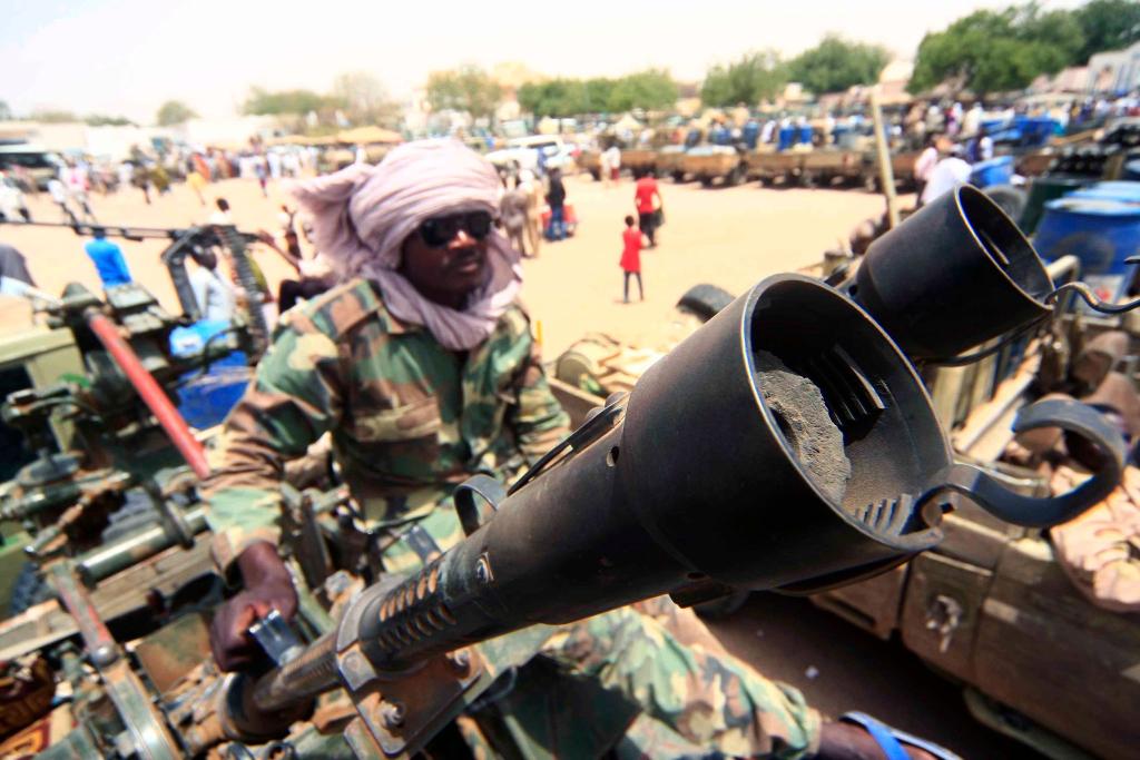 Ein Milizionär sitzt neben militärischer Ausrüstung, die angeblich während eines Gefechts im umkämpften Gebiet in Süd-Darfur erbeutet wurde. - Foto: Marwan Ali/EPA/dpa