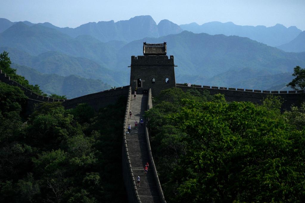Bei diesem Anblick macht das Schwitzen sicher gleich viel mehr Spaß: Läuferinnen und Läufer bahnen sich ihren Weg auf einem schmalen und steilen Abschnitt entlang der berühmten Chinesischen Mauer. Sie nehmen am Great Wall Marathon teil. - Foto: Andy Wong/AP/dpa