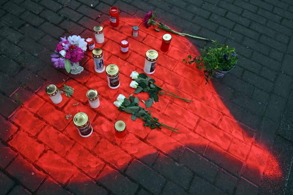 Kerzen und Blumen liegen in einem auf das Pflaster gesprühten roten Herzen in Düsseldorf nach dem mörderischen Brandanschlag. - Foto: Federico Gambarini/dpa