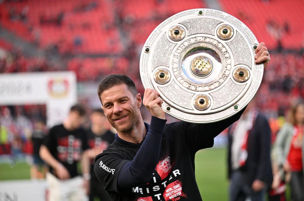 28 Siege und sechs Unentschieden: Leverkusen-Trainer Xabi Alonso jubelt mit der Meisterschale. - Foto: Marius Becker/dpa