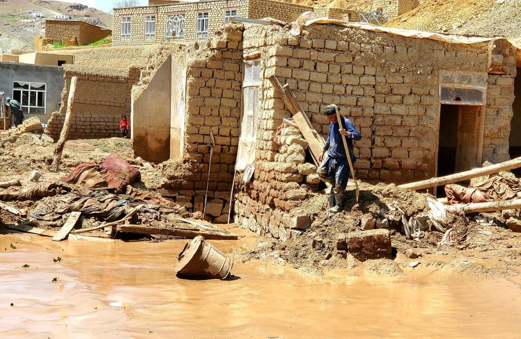 Ein Mann sammelt nach schweren Überschwemmungen in der Provinz Ghor seine Habseligkeiten zusammen. - Foto: Omid Haqjoo/AP/dpa
