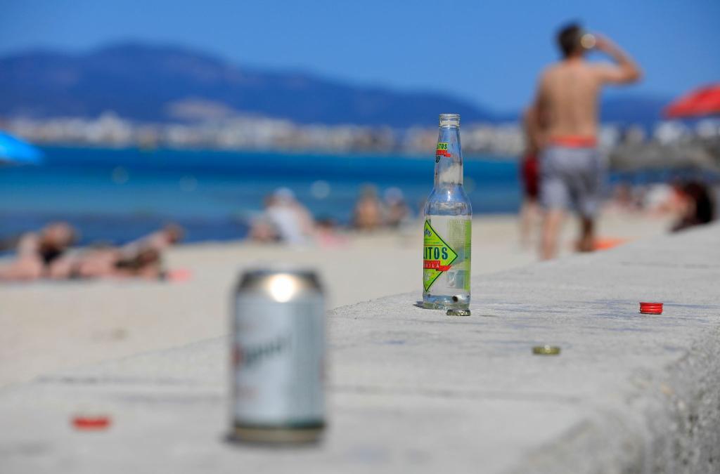 Leere Flaschen und Dosen am Strand auf Mallorca. - Foto: Clara Margais/dpa