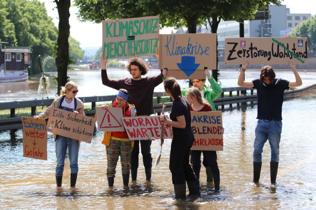 Im Saarbrücken protestieren Klimaaktivisten der Gruppe «Fridays for Futuren» auf der überfluteten Autobahn 620. Die Aktivisten werfen Bundeskanzler Scholz vor, bei seiner Ansprache vor Ort «die Klimakrise fahrlässig ausgeblendet» zu haben. - Foto: Christian Wiediger/dpa