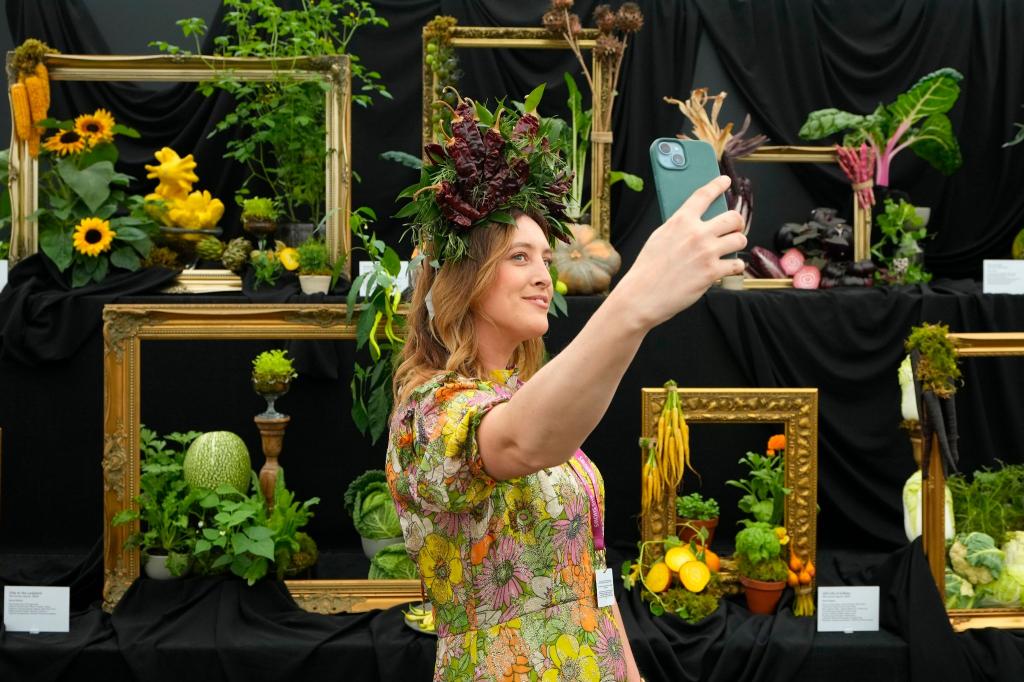 Die jährliche Gartenmesse Chelsea Flower Show in London zieht viele Besucher an. So wie diese Frau mit passender Kopfbedeckung. - Foto: Kirsty Wigglesworth/AP/dpa