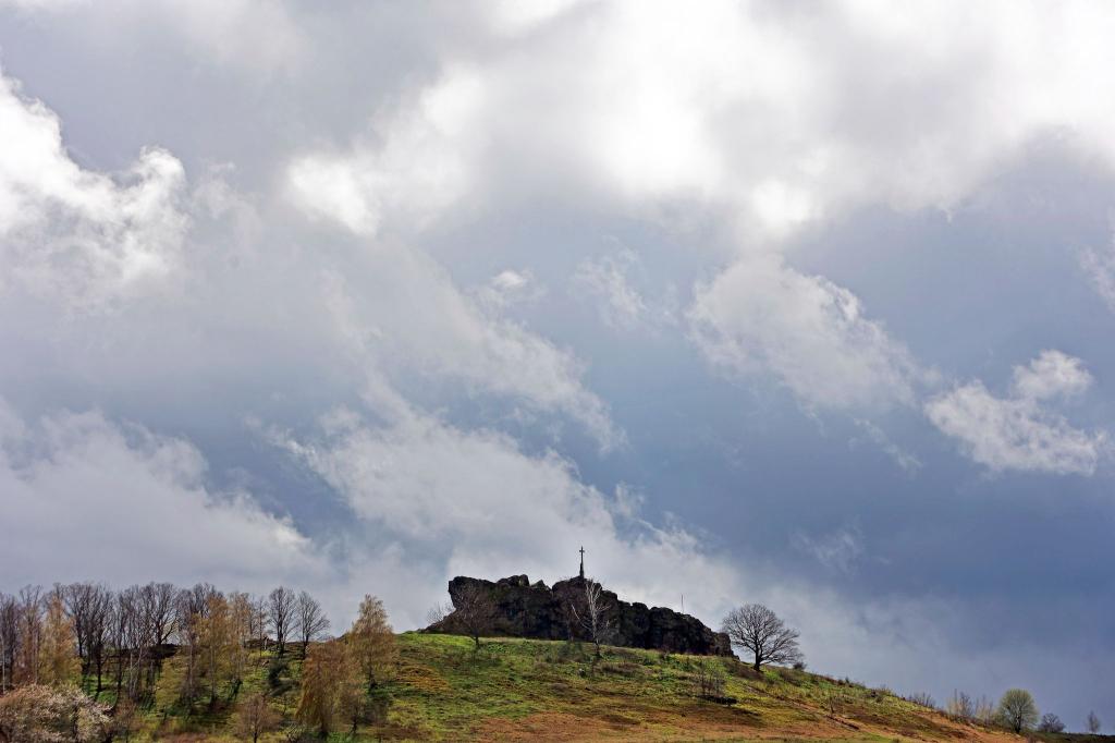 Dunkle Wolken ziehen über die Gegensteine im Harzvorland. - Foto: Matthias Bein/dpa