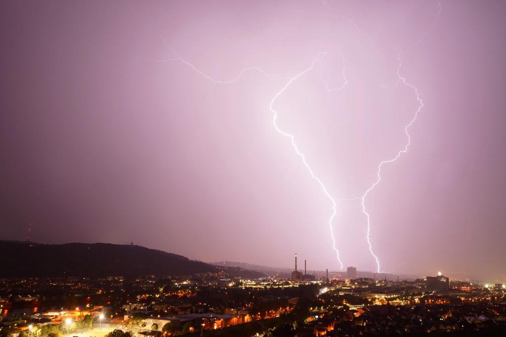 Zwei Blitze entladen sich bei einem Gewitter über Stuttgart. - Foto: Andreas Rosar/dpa