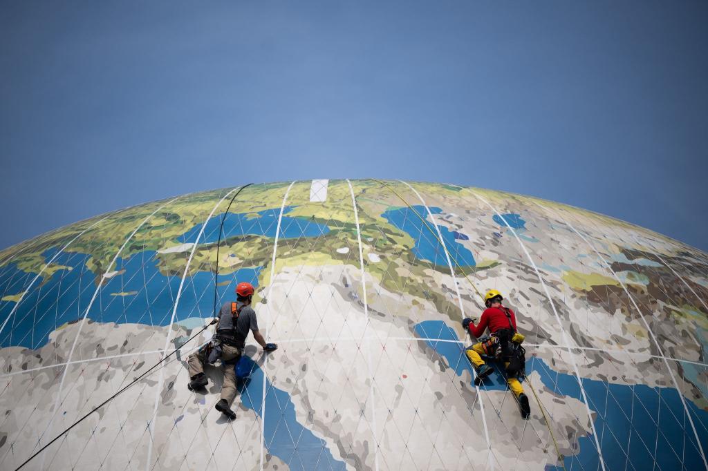 Weltweite Suche: Kletterer warten den Weltballon des Air Service Berlin nahe des Checkpoint Charlie. Mit dem Ballon können Passagiere in die Höhe steigen und auf Berlin herabblicken. - Foto: Sebastian Gollnow/dpa