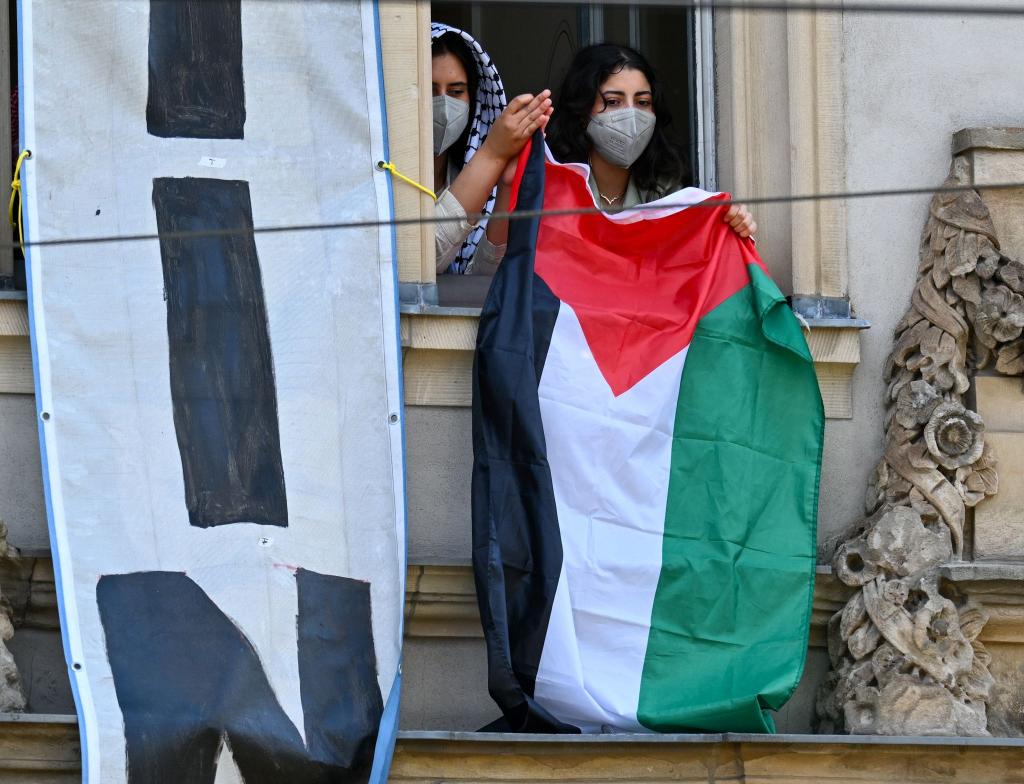 Pro-Palästinensische Demonstranten halten aus einem Fenster des Institutes für Sozialwissenschaften der Berliner Humboldt-Universität eine palästinensische Flagge. Zur Unterstützung der Palästinenser im Gazastreifen und aus Protest gegen Israel haben sie Räume der Uni besetzt. - Foto: Soeren Stache/dpa