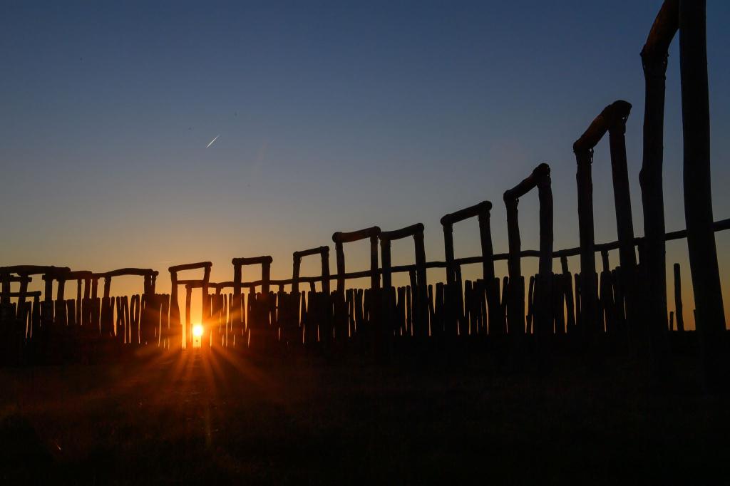 Beeindruckender Moment an einem besonderen Ort: Die Sonne geht hinter den Stelen und Toren vom Ringheiligtum Pömmelte unter. Am 20. März 2025 ist Frühlingsanfang und somit Tag-und-Nacht-Gleiche. - Foto: Klaus-Dietmar Gabbert/dpa