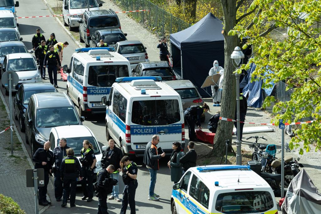 Polizisten und Beamte der Spurensicherung in weißen Schutzanzügen stehen an dem Ort, wo ein toter Mann gefunden wurde. - Foto: Hannes P. Albert/dpa
