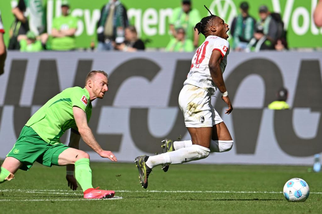 Wolfsburgs Maximilian Arnold foult Freiburgs Junior Adamu und sieht dafür die Rote Karte. - Foto: Swen Pförtner/dpa