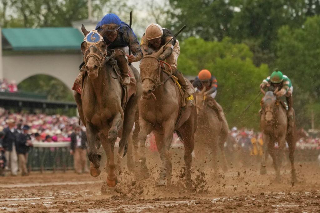 Good Cheer, geritten von Luis Saez, links, steuert auf die Ziellinie zu, um das 151. Kentucky Oaks Pferderennen in Churchill Downs in Louisville, Kentucky, zu gewinnen. Nach Regenfällen über der Rennbahn ist das Geläuf sehr matschig geworden. - Foto: Abbie Parr/AP/dpa
