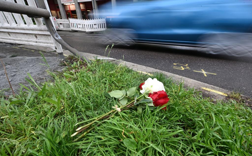 Am Tag nach dem Unfall liegen Rosen am Straßenrand. - Foto: Bernd Weißbrod/dpa