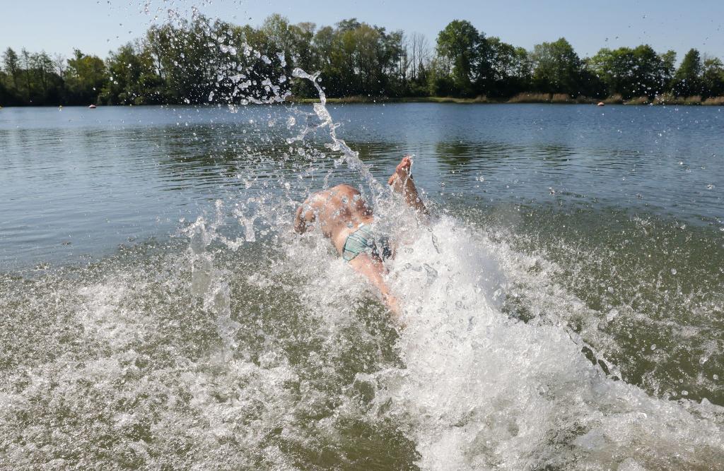 Wetter in Baden-Württemberg: Ein Mann springt im Sonnenschein in den sechzehn Grad warmen Schwarzachtalsee. - Foto: Thomas Warnack/dpa