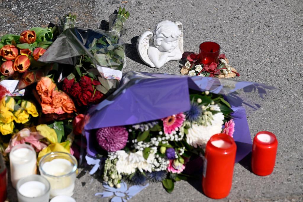 Zeichen der Anteilnahme: Auf einem Bürgersteig an dem Spielplatz sind Kerzen und Blumen niedergelegt worden. - Foto: Roberto Pfeil/dpa