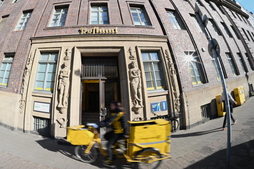 Eine Briefträgerin fährt an einer Postfiliale vorbei - vielleicht ist auch sie eine Beamtin? - Foto: Wolf von Dewitz/dpa