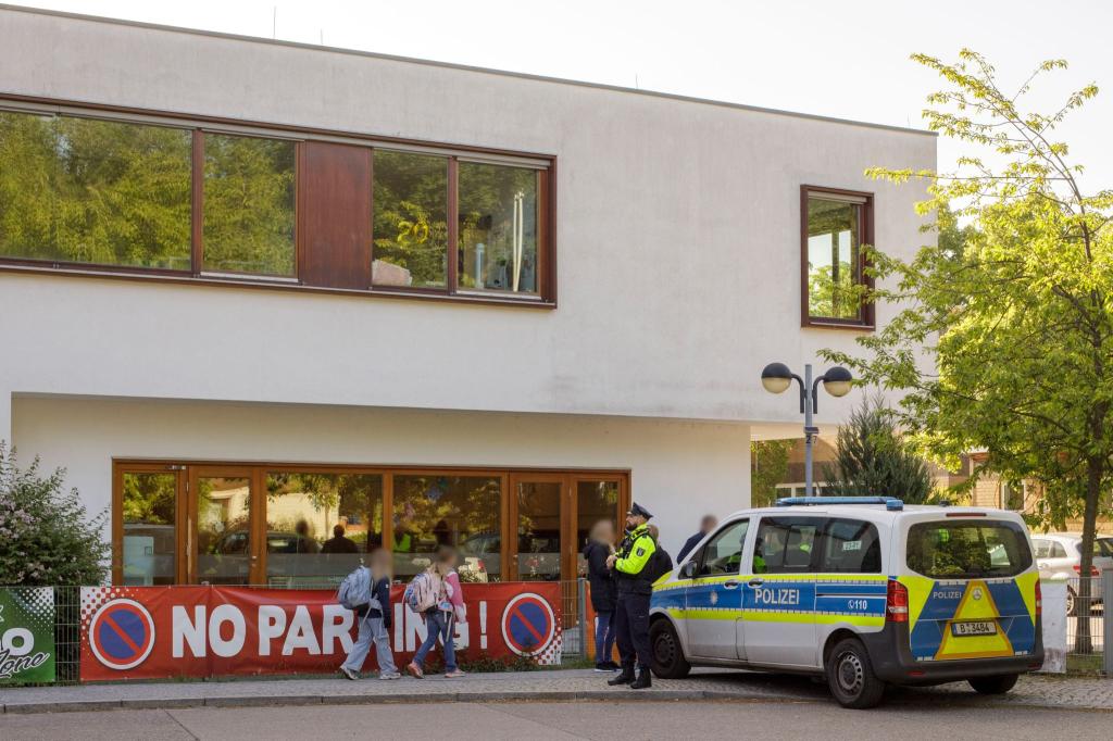 Die Polizei steht vor einer Grundschule im Berliner Bezirk Spandau, während Schüler am Morgen zur Schule kommen. - Foto: Julius-Christian Schreiner/dpa