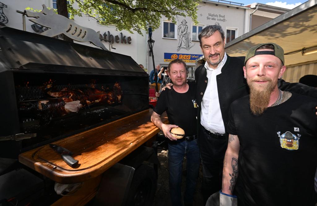 Ministerpräsident Söder am Schweinegrill. - Foto: Felix Hörhager/dpa