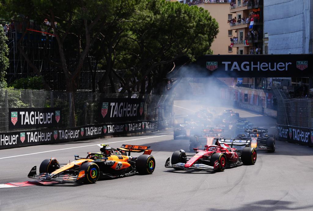 Lando Norris verteidigt in der ersten Kurve die Führung vor Charles Leclerc. - Foto: David Davies/PA Wire/dpa