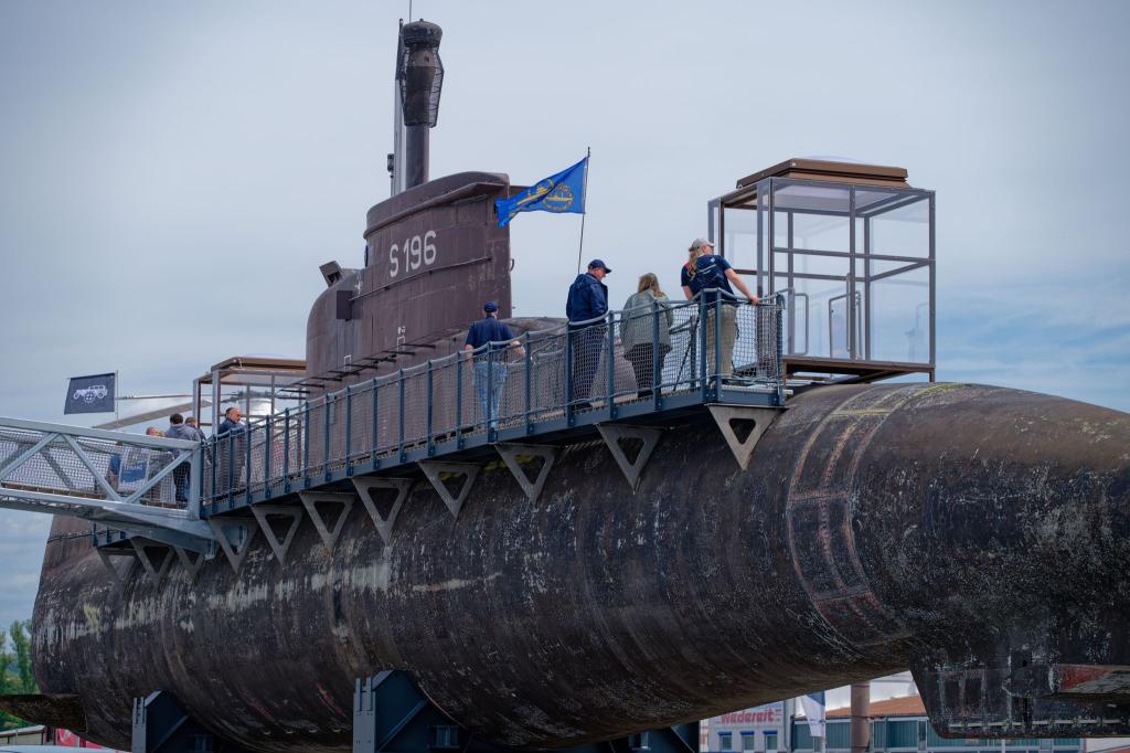 Besucher gehen über einen Steg am Marine U-Boot U17 entlang. - Foto: Uwe Anspach/dpa