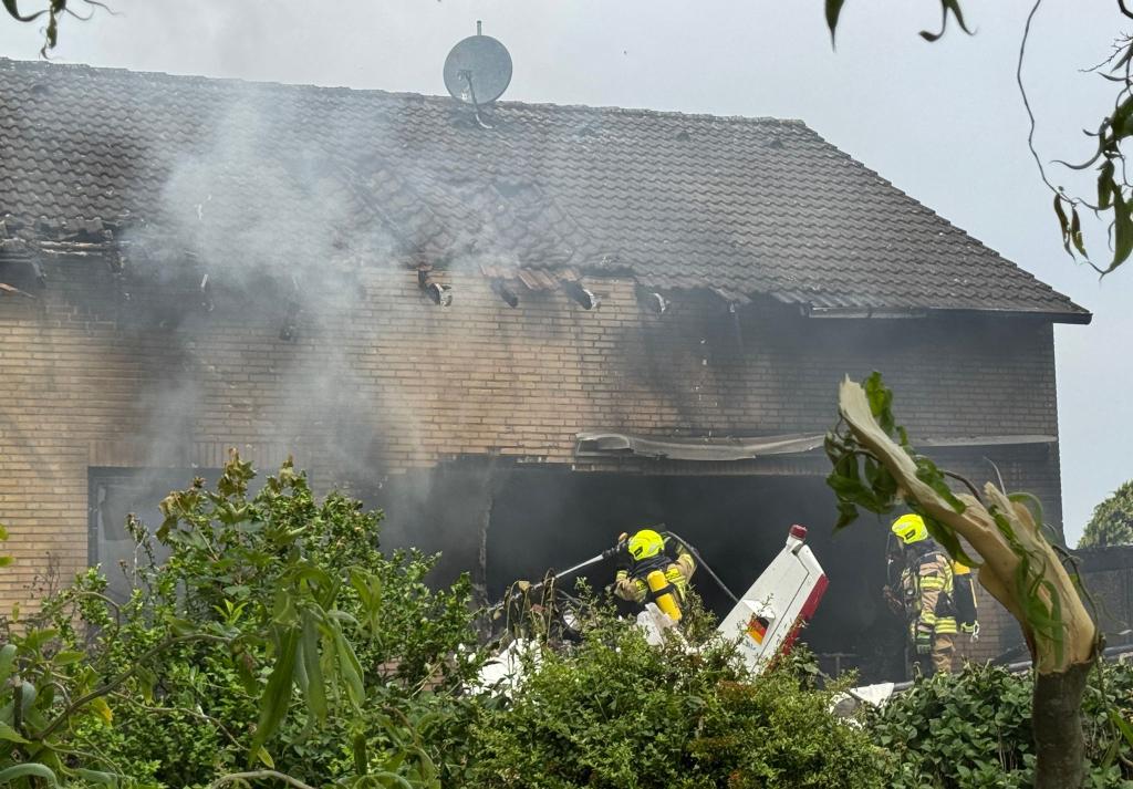 Die Feuerwehr arbeitet an der Absturzstelle, nachdem ein Flugzeug in ein Wohnhaus gestürzt ist. - Foto: Sascha Rixkens/Einsatzreport Niederrhein/dpa