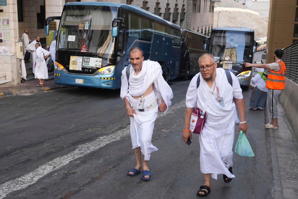 Pilger bereiten sich während der jährlichen Hadsch-Pilgerfahrt in der muslimischen heiligen Stadt Mekka auf die Fahrt mit einem Bus von Mekka nach Arafat vor. - Foto: Amr Nabil/AP/dpa