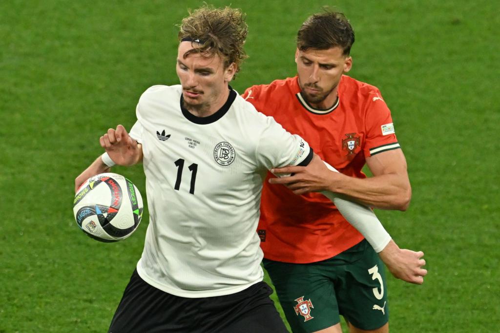 Nick Woltemade (l) hatte bei seinem Länderspiel-Debüt gegen Portugals Abwehrrecken einen schweren Stand. - Foto: Peter Kneffel/dpa