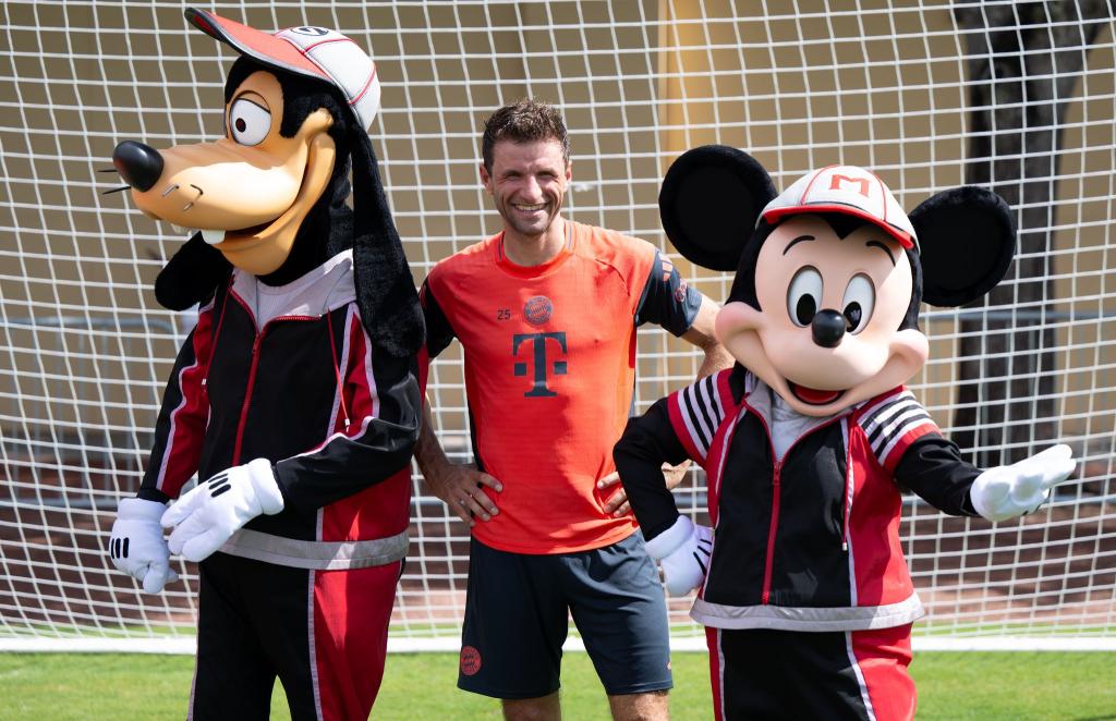 Thomas Müller mit Goofy und Micky Maus. - Foto: Sven Hoppe/dpa