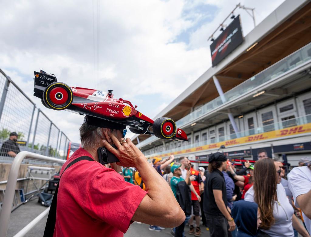 Formel 1: Ein Fan trägt einen kleinen Ferrari als Hut am Tag der offenen Tür beim Großen Preis von Kanada in Montreal. - Foto: Christinne Muschi/The Canadian Press/AP/dpa