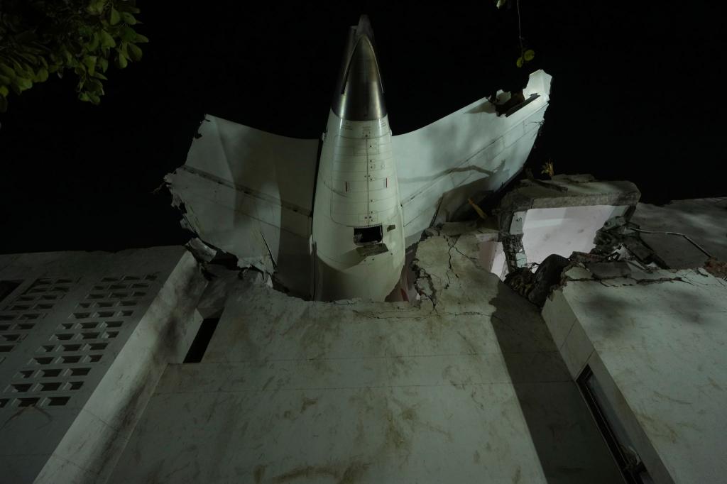 Das Heck des Flugzeugs steckt in einem Gebäude an der Absturzstelle in der nordwestindischen Stadt Ahmedabad im Bundesstaat Gujarat. (Foto aktuell) - Foto: Ajit Solanki/AP/dpa
