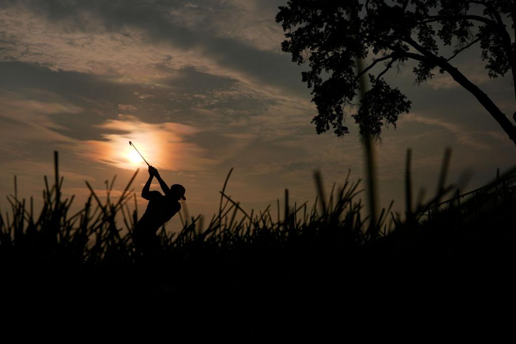 Golf kann so romantisch sein: Adam Schenk schlägt am 10. Loch im Gegenlicht der Sonne während der zweiten Runde des US Open Golfturniers in Oakmont im US-Staat Pennsylvania ab. - Foto: Carolyn Kaster/AP/dpa