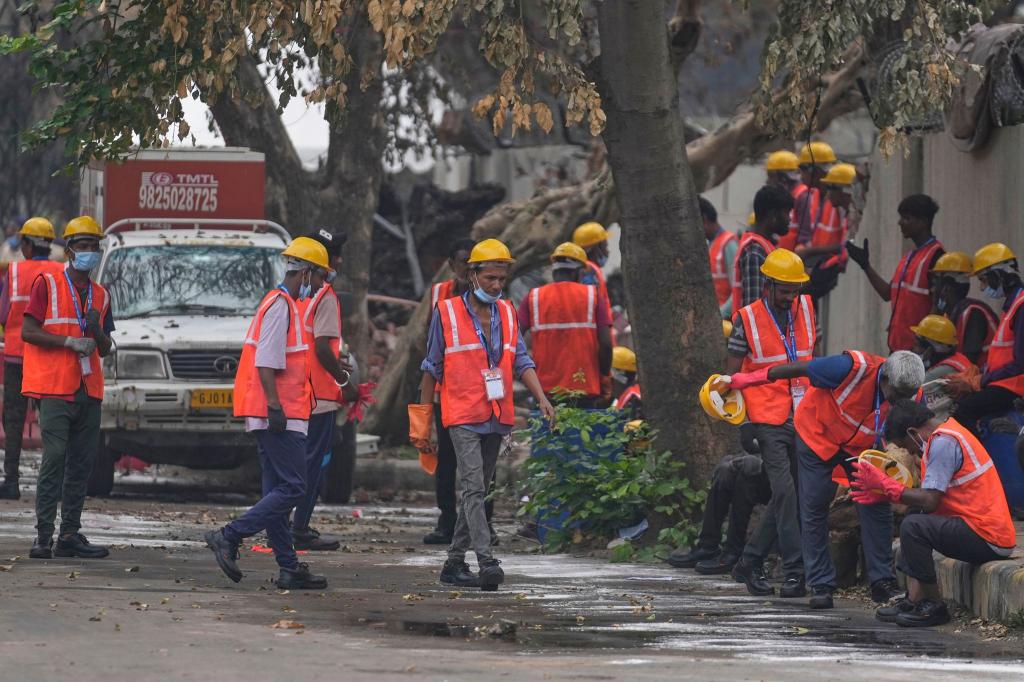 Arbeiter sind an der Absturzstelle im Einsatz. - Foto: Rafiq Maqbool/AP/dpa