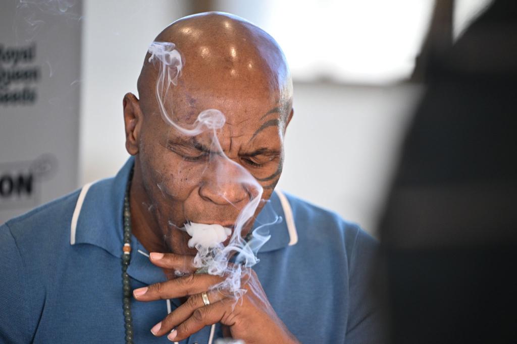 Box-Ikone und Cannabis-Unternehmer Mike Tyson raucht an einem Stand der Cannabis-Messe Mary Jane einen Joint. - Foto: Sebastian Gollnow/dpa