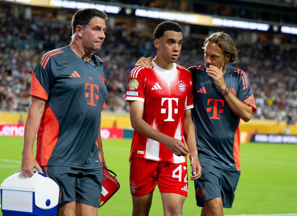 Jamal Musiala musste nur 25 Minuten nach seiner Einwechselung angeschlagen vom Platz, begleitet von Teamarzt (r) und Physiotherapeut. - Foto: Sven Hoppe/dpa